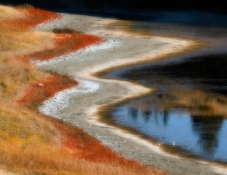 Low water lakeside with beach and orange grass